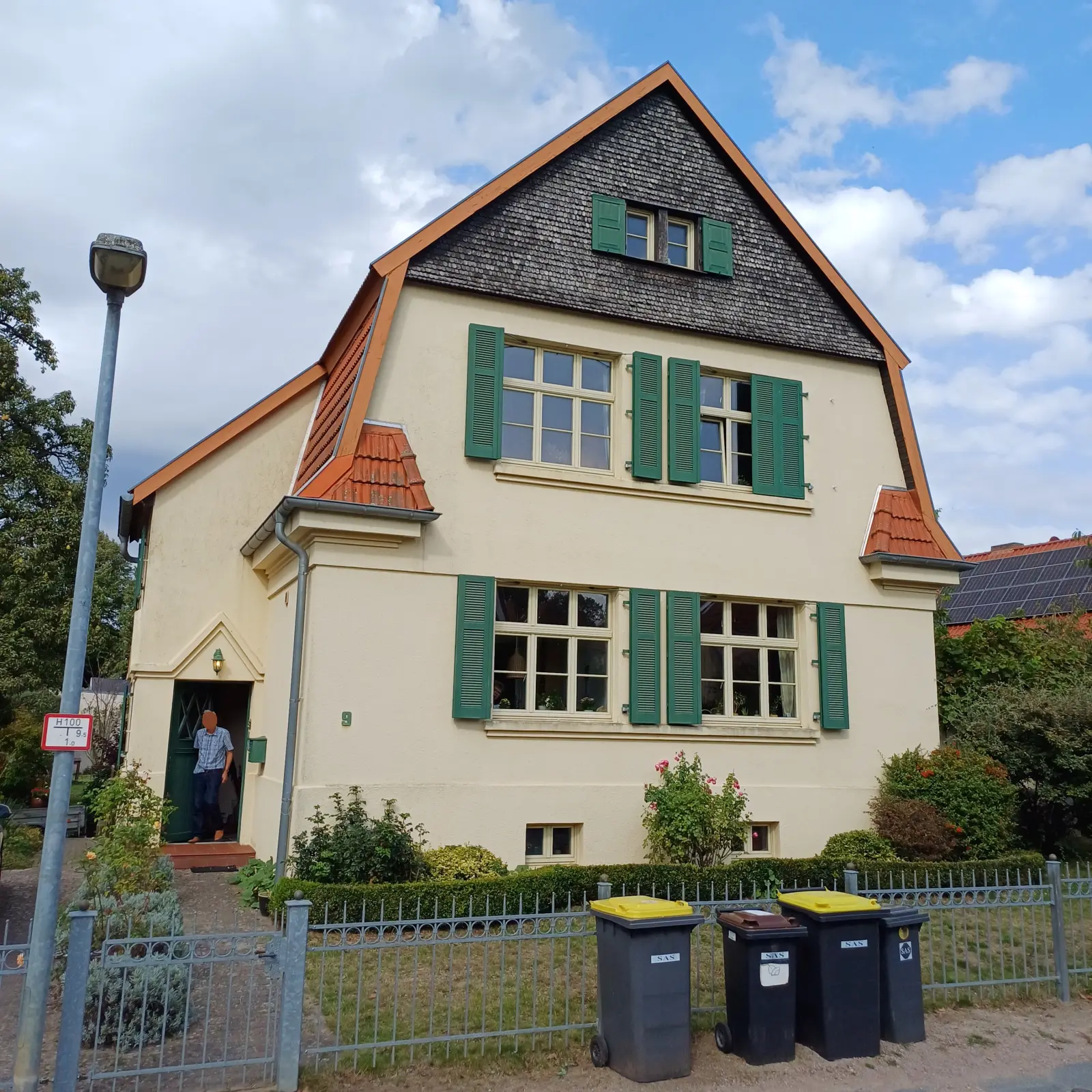 Helles Wohnhaus mit grünen Fensterläden und Krüppelwalmdach, Am Kreuzweg 9
