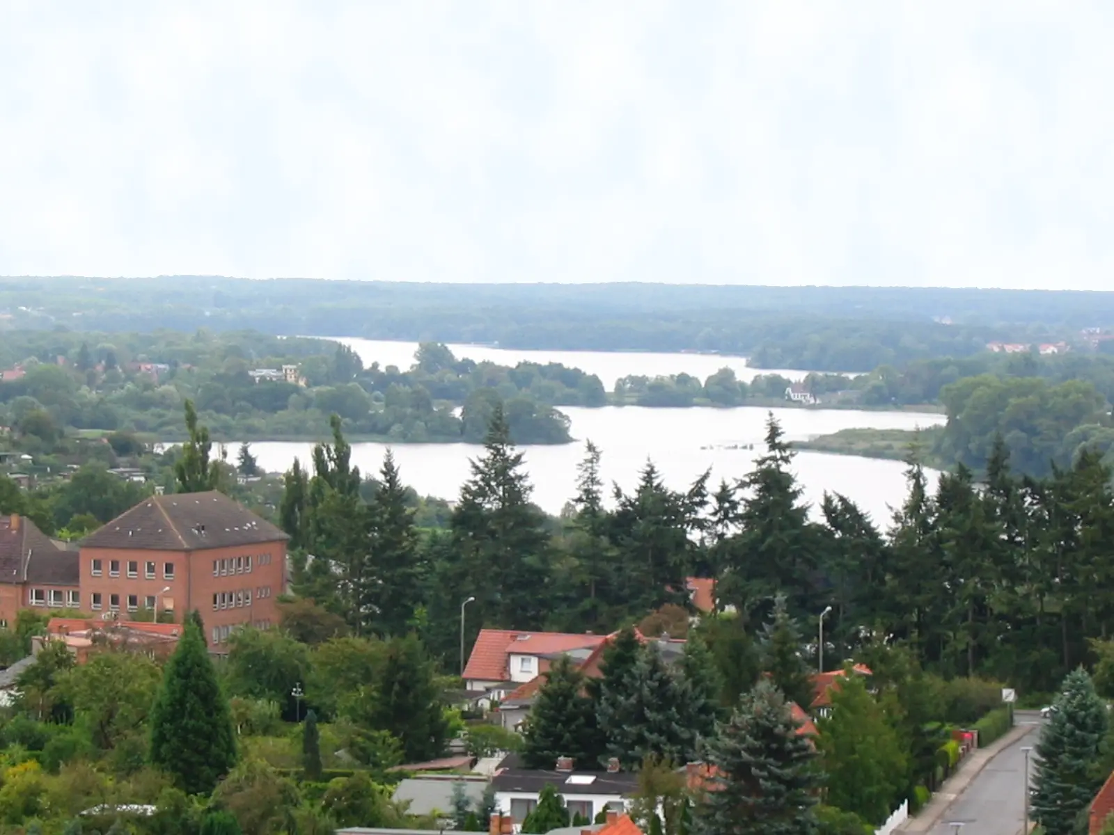 Blick über Dächer und Bäume auf den Ostorfer See mit seinen Inseln